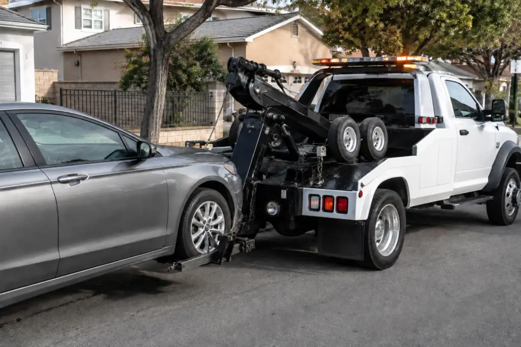 Tow truck lifting gray sedan wheels | A1 Nationwide